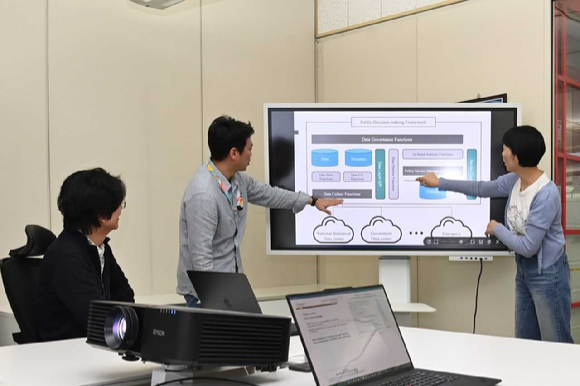 ETRI 연구진이 AI 기반 공공 의사결정 프레임워크 구조를 검토하며 정책지능 기술 적용 방안을 논의하는 모습. [사진=ETRI]