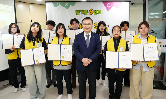 류경기 중랑구청장이 3월 27일 열린 '딩가동 6번지 개소식'에서 새롭게 위촉된 청소년운영위원회 위원들과 기념 촬영을 하고 있다. [사진=중랑구]