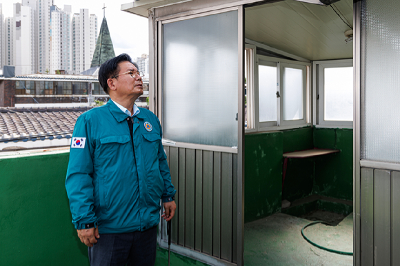 박강수 마포구청장이 옥탑의 오래된 창호를 살펴보고 있다. [사진=마포구]