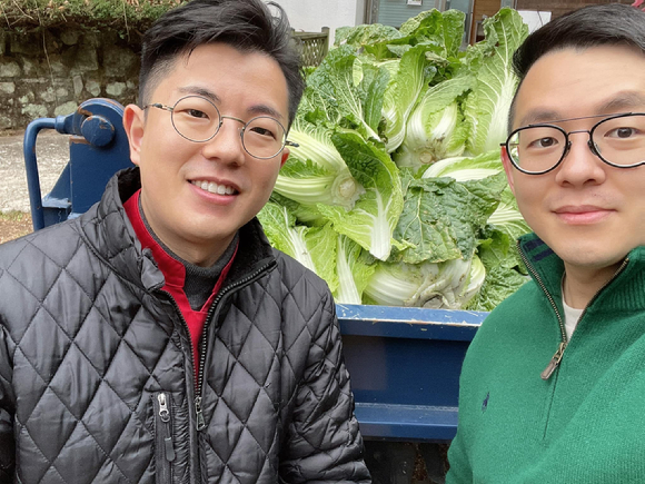 (왼쪽부터) '시골밥상' 쉐프인 김주엽씨와 '백련동편백농원' 김진환 대표가 직접 심은 배추를 수확하고 있다. [사진=김진환 대표 페이스북]