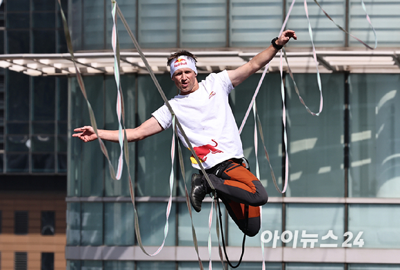 세계적인 슬랙라인 선수 얀 루스(Jaan Roose)가 1일 서울 광화문 사거리 상공 120m 높이에서 '레드불 서울 줄타기' 퍼포먼스를 선보이고 있다. [사진=정소희 기자]