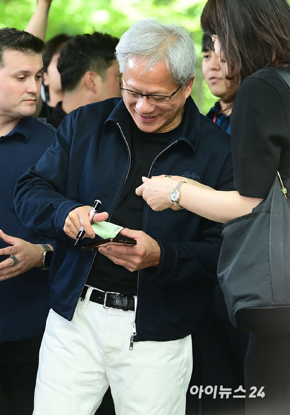 젠슨 황 엔비디아 최고경영자(CEO)가 5일 오후 전세기를 통해 서울김포비즈니스항공센터로 입국해 시민들의 사인 요청에 응하고 있다. 한 시민이 만원권 지폐에 사인을 요청하자 주머니에 넣을려는 유머스러운 제스쳐을 하며 웃는 젠슨 황의 모습. [사진=정소희 기자]