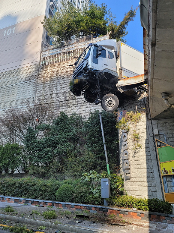 4.5t 트럭이 고가도로 난간을 뚫고 매달려있다. [사진=부산지방경찰청]