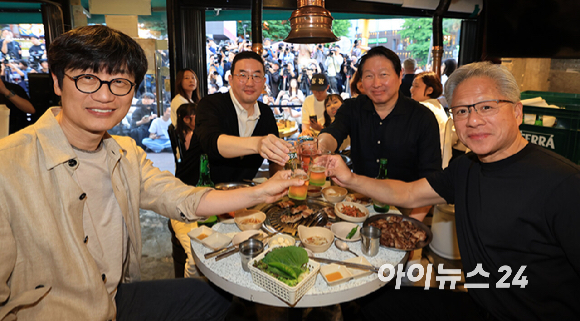 최태원 SK그룹 회장(왼쪽)과 젠슨 황 엔비디아 최고경영자(CEO)가 5일 서울 마포구 홍대 삼겹살집 '형님저요' 앞에서 SK하이닉스 HBM(고대역폭메모리) 과자칩을 들고 시민들과 소통하고 있다. [사진=정유림 기자]