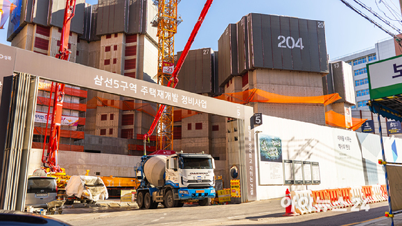 19일 낙산공원에서 바라본 성북구 삼선동 일대 노후 주택과 맞물린 창경궁 롯데캐슬 시공현장. [사진=김민지 기자]