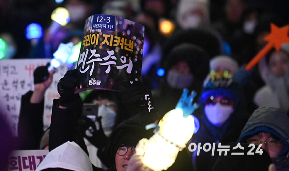 12·3 비상계엄 1년을 맞은 3일 서울 여의도 국회 앞에서 열린 '12·3 내란외환 청산과 종식, 사회대개혁 시민대행진'에서 시민들이 응원봉과 피켓을 흔들고 있다. [사진=곽영래 기자]