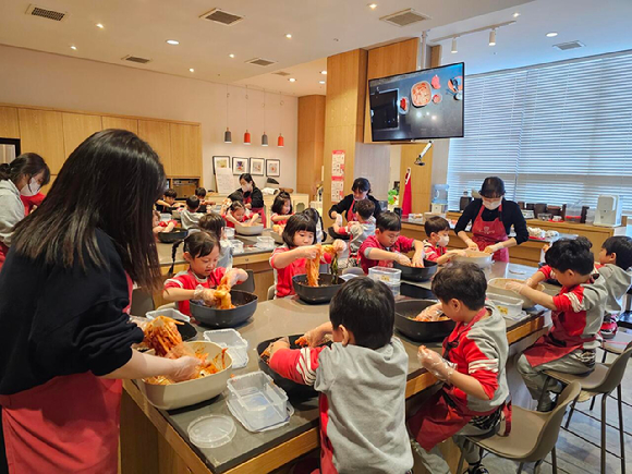 풀무원 뮤지엄김치간의 '어린이 김치학교'에 참여한 어린이와 학부모들이 김치 만들기 체험을 하고 있다. [사진=풀무원]