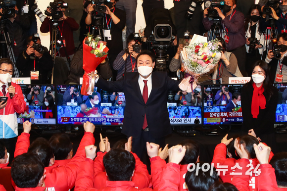 윤석열 제20대 대통령 당선인이 10일 새벽 국회 도서관에 마련된 개표상황실을 찾아 당선 축하 꽃다발을 들어보이고 있다. [사진=김성진 기자]