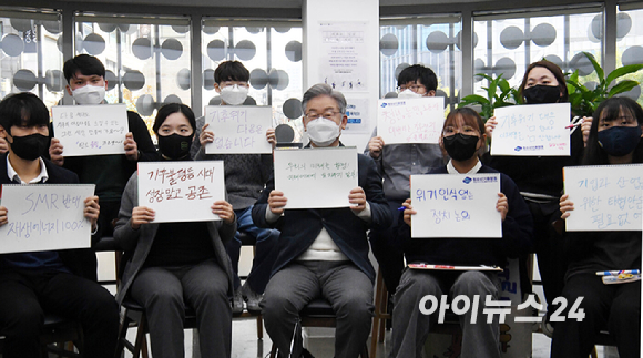 이재명 더불어민주당 대선후보가 16일 오전 서대문구 청년문화공간 신촌 파랑고래에서 청소년 청년 기후활동가들과 기후위기를 주제로 간담회를 가졌다. 간담회에 앞서 구호가 적힌 손팻말을 들고 있다. [사진=국회사진취재단]