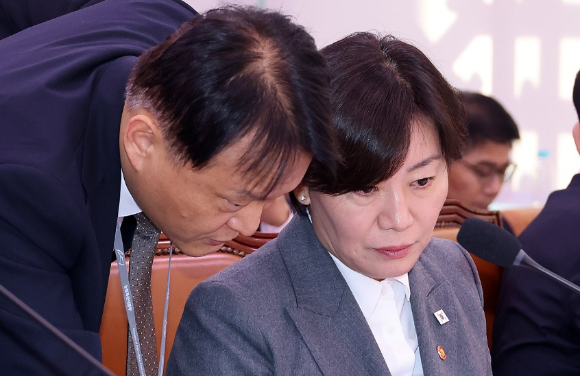 7일 국회에서 열린 농림축산식품해양수산위원회 국정감사에서 국민의힘 위원들이 "농민 몰아내서 결국 태양광이냐"라고 쓰인 피켓을 앞에 걸었다가 더불어민주당 위원들의 요구에 떼어내고 있다. [사진=연합뉴스]