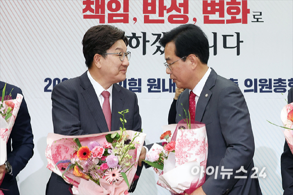 송언석 국민의힘 신임 원내대표가 16일 오후 서울 여의도 국회에서 열린 2025 국민의힘 원내대표 선출 의원총회에서 꽃다발을 든 채 손을 들어올리고 있다. [사진=곽영래 기자]