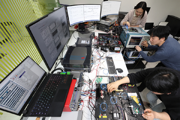 KT 직원들이 양자 암호키 분배 장비를 사용하는 모습. [사진=KT]