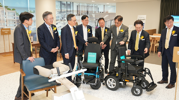 서울 강남구 역삼동 KB라이프타워에 마련한 에이지테크랩(Age Tech Lab)에서 조영서 KB금융지주 전략 담당 부사장(왼쪽에서 두 번째), 정문철 KB라이프 대표(왼쪽에서 세 번째), 박병곤 KB국민은행 부행장(왼쪽에서 일곱 번째)이 전동 휠체어 체험을 하고 있다. [사진=KB금융그룹]