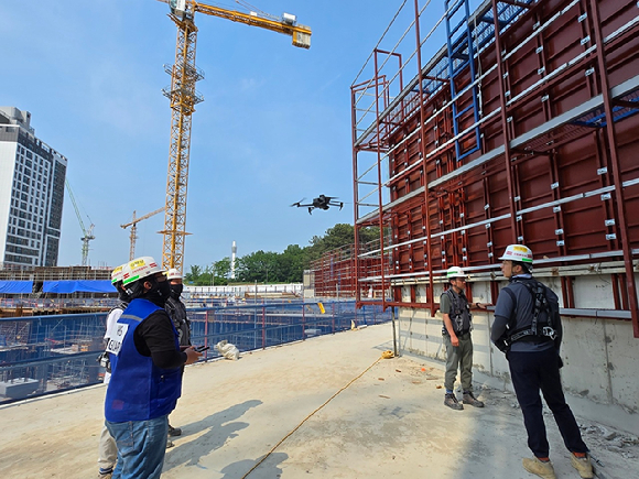 HDC현대산업개발 임직원이 드론을 활용해 현장 관리를 하고 있다. [사진=HDC현대산업개발]