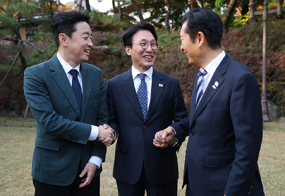 김민석 국무총리(가운데)가 9일 서울 종로구 총리공관에서 열린 고위당정협의회에서 강훈식 대통령 비서실장(왼쪽), 더불어민주당 정청래 대표와 손을 잡고 있다. 2025.11.9 [사진=연합뉴스]