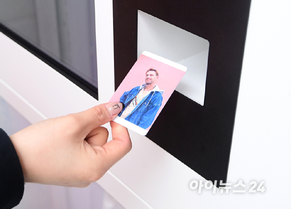 10일 서울 여의도 한강공원에서 열린 '2026 서울 스프링 페스티벌' 케이팝아케이드 부스에서 외국인 관광객이 포토카드 만들기 체험을 하고 즐거워하고 있다. [사진=정소희 기자]