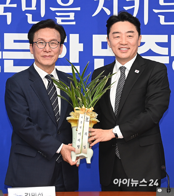 김민석 더불어민주당 신임 당대표가 18일 서울 여의도 국회에서 강훈식 대통령 비서실장으로부터 이재명 대통령 명의 축하 난을 전달받고 있다. [사진=곽영래 기자]