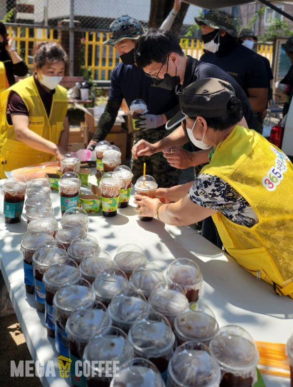 관악구 자원봉사센터에 메가커피가 가맹점주 등과 함께 음료를 지원하고 있는 모습. [사진=메가커피]