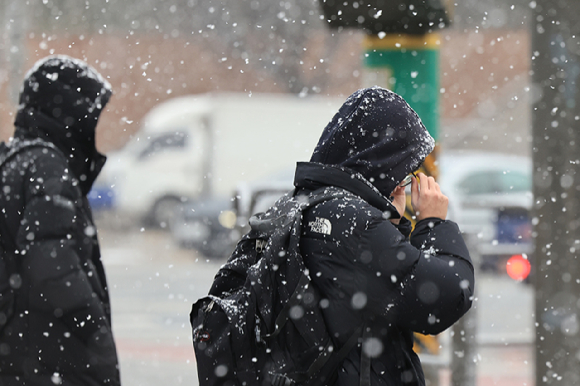 지난 6일 서울 서초구 삼호가든사거리에서 시민들이 눈을 맞으며 횡단보도를 건너고 있다. [사진=연합뉴스]