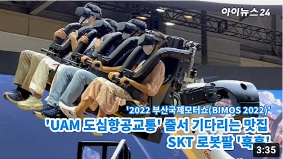 SKT 전시관 관람객들이 대형 로봇팔 시뮬레이터 위에 올라 마치 UAM 항공기에 탑승해 비행하는 듯한 체험을 하는 모습. [사진=김문기 기자]