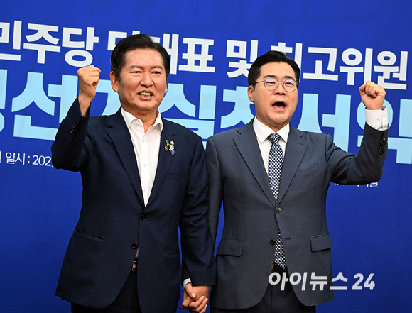 더불어민주당 정청래(왼쪽)·박찬대 당대표 후보가 15일 국회에서 열린 공명선거실천서약식에서 서약서에 서명한 뒤 기념촬영 하고 있다. [사진=곽영래 기자]