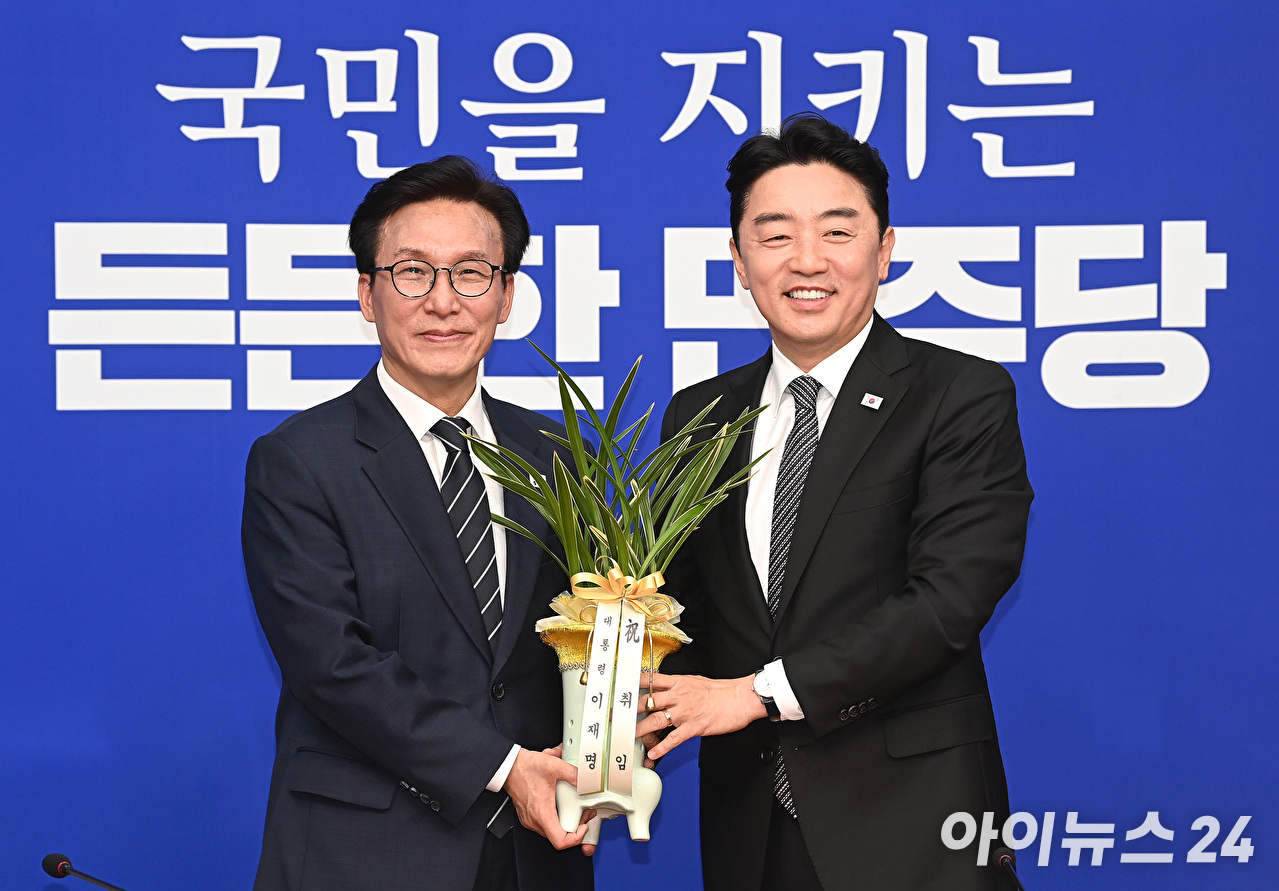 김민석 더불어민주당 신임 당대표가 18일 서울 여의도 국회에서 강훈식 대통령 비서실장으로부터 이재명 대통령 명의 축하 난을 전달받고 있다. [사진=곽영래 기자]