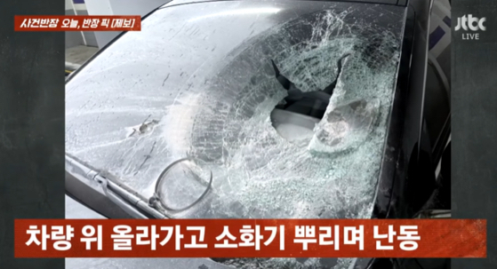멀쩡히 주차돼 있던 차량이 흉기를 든 남성에 의해 파손되는 아찔한 사건을 경험했다는 차주의 제보가 전해졌다. 사진은 흉기를 든 채 돌아다니는 남성의 모습. [사진=JTBC]