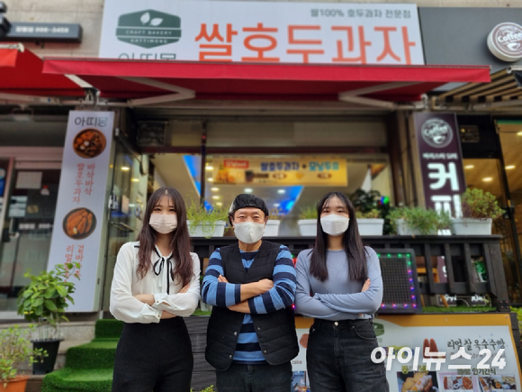 KT 잘나가게 프로젝트 참가자들이 호두과제 전문점 '아띠몽' 가게 앞에서 기념 촬영하고 있는 모습. 왼쪽부터 채승원 대학생(19세)·장호 아띠몽 사장(70세)·김다연 대학생(21세). [사진=안세준 기자]