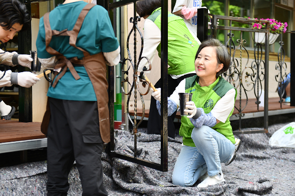 28일 서울 마포의 '성산행복한홈스쿨'에서 서창희(맨 오른쪽) 코오롱사회봉사단장이 테라스 목재를 개보수하고 있다. [사진=코오롱]