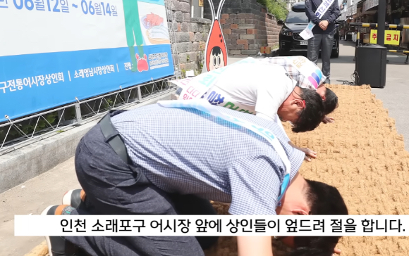 인천시 남동구 소래포구 전통어시장에서 상인들이 자정대회를 열고 신뢰 회복을 약속하며 절을 하고 있다. [사진=MBC 보도 영상 캡처]