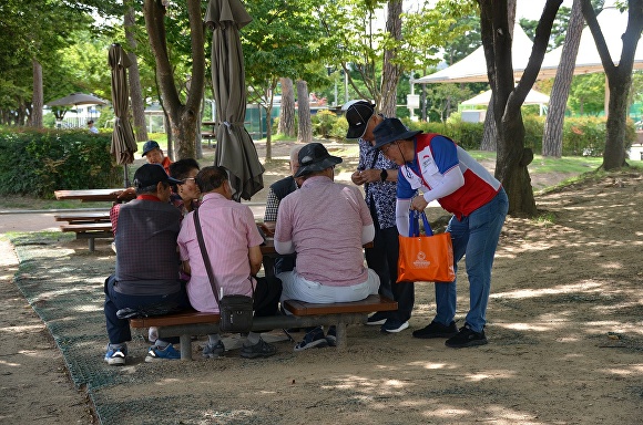 대구 수성구자원봉사센터 자원봉사자들이 지역주민들에게 ‘청라수’를 배부하고 있다. [사진=수성구]