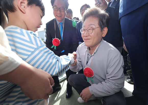 더불어민주당 이재명 대선 후보가 7일 전북 익산시 대한노인회 익산시지회에서 열린 노인회 간담회에 참석하던 중 어린이로부터 카네이션 목걸이를 받고 있다. 2025.5.7 [사진=연합뉴스]