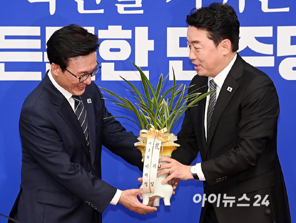 김민석 더불어민주당 신임 당대표가 18일 서울 여의도 국회에서 강훈식 대통령 비서실장으로부터 이재명 대통령 명의 축하 난을 전달받고 있다. [사진=곽영래 기자]