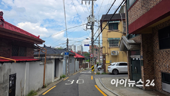 18일 서울 성북구 장위동 장위15구역 내 골목. 뒤로 장위4구역(장위자이 레디언트)가 보인다. [사진=이수현 기자]