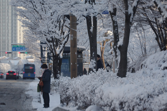 눈이 내린 지난 8일 전주시 완산구의 한 도로에서 시민이 출근길을 재촉하고 있다. [사진=연합뉴스]