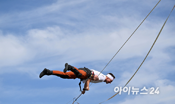 세계적인 슬랙라인 선수 얀 루스(Jaan Roose)가 1일 서울 광화문 사거리 상공 120m 높이에서 '레드불 서울 줄타기' 퍼포먼스를 선보이고 있다. [사진=정소희 기자]