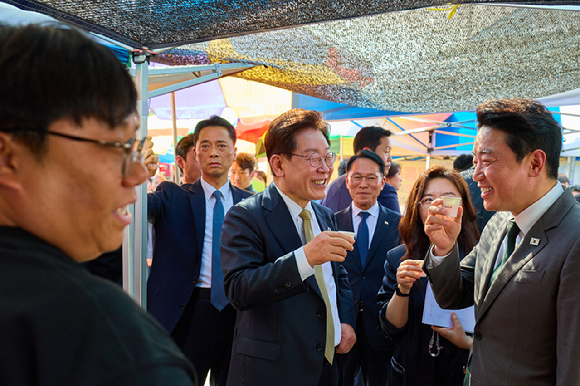 이재명 대통령이 14일 성남 모란시장에서 강훈식 비서실장과 시식을 하며 대화하고 있다. 2026.5.14 [청와대 제공. 재판매 및 DB 금지] [사진=연합뉴스]