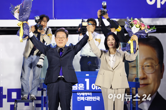 이재명 대통령와 김혜경 여사가 4일 오전 서울 여의도 국회 앞에서 열린 국민 개표방송 행사에서 꽃다발을 받은 뒤 시민들을 향해 인사하고 있다. [사진=곽영래 기자]