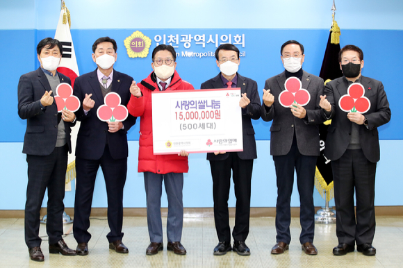 인천광역시의회는 15일 의장 접견실에서 불우이웃 돕기 사랑의 쌀 기부금 전달식을 개최했다. 참석자들이 사랑의 하트를 날리고 있다. [사진=인천시의회]