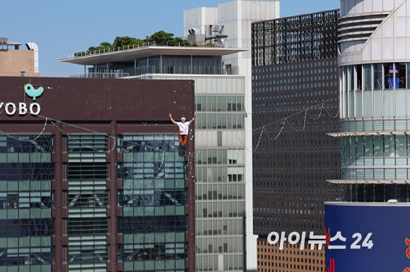 세계적인 슬랙라인 선수 얀 루스(Jaan Roose)가 1일 서울 광화문 사거리 상공 120m 높이에서 '레드불 서울 줄타기' 퍼포먼스를 선보이고 있다. [사진=정소희 기자]