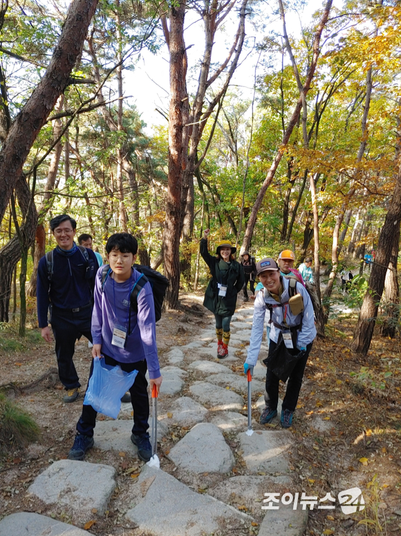 29일 서울 은평구 대서문길 북한산성분소 인근에서 진행된 '산악인 오은선과 함께 하는 제6회 희망찾기 등산·트레킹 교실'에서 홍보대사로 참석한 가수 강소리 응원속에 참가자들이 플로깅을 하고 있다. [사진=정소희 기자]