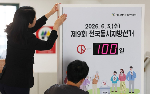 6&middot;3 지방선거를 100일 앞둔 23일 서울 종로구 서울특별시선거관리위원회에서 선관위 직원들이 안내판 스티커를 붙이고 있다. [사진=연합뉴스]