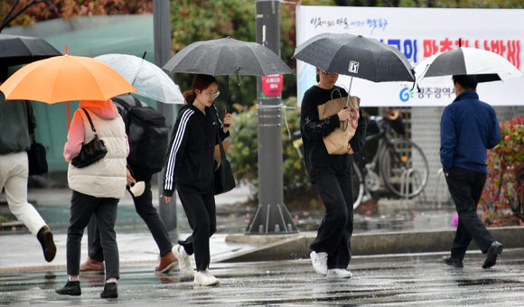 봄비가 내린 22일 오후 광주 동구청 주변 교차로에서 시민들이 우산을 쓴 채 횡단보도를 걷고 있다. [사진=뉴시스]