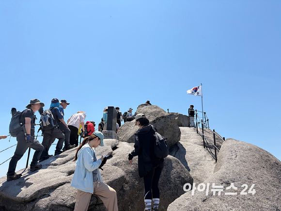 화창한 봄날 날씨를 보인 9일 북한산 정상 백운대를 찾은 등산객들이 인증샷을 찍기 위해 긴 행렬을 보이고 있다. [사진=정소희 기자]