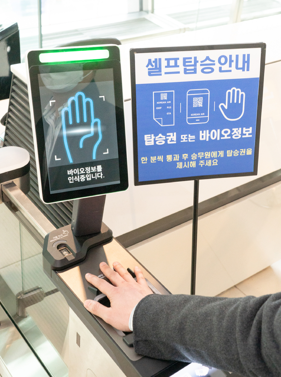 김포공항 탑승구 앞에서 승객이 '바이오 셀프보딩 서비스'를 이용하고 있는 모습이다. [사진=대한항공]