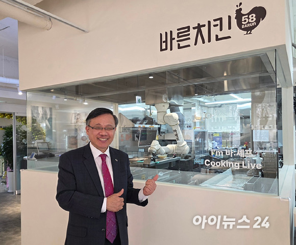 관절형 로봇이 움직이며 치킨을 조리하고 있다. [사진=구서윤 기자]