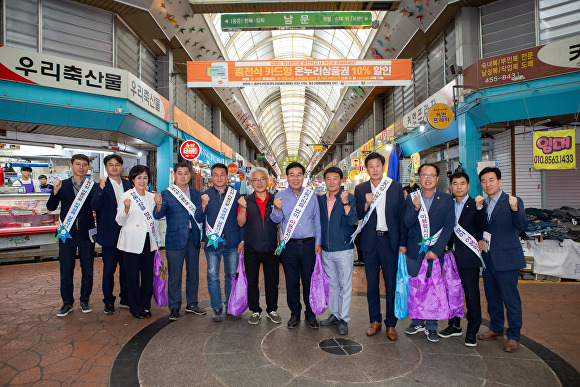 25일 구미 전통시장을 찾은 구미시의회 직원들과 확대의장단 의원들이 제수용품을 구입한 뒤 기념촬영을 하고 있다. [사진=구미시의회]