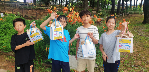 연곡초등학교 학생들이 직접 수확한 표고버섯을 들어 보이고 있다. [사진=산림조합중앙회/산림버섯연구소]