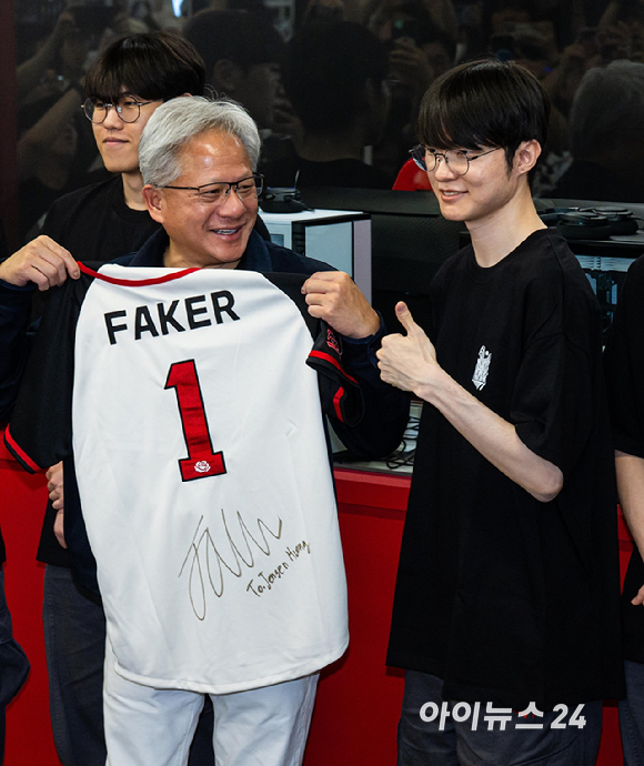 젠슨 황 엔비디아 최고경영자(CEO)가 5일 서울 마포구 &lsquo;T1 베이스 캠프&rsquo;를 방문해 &lsquo;페이커&lsquo; 이상혁을 비롯한 e스포츠 구단 T1의 리그 오브 레전드(LoL) 선수단을 만나서 &lsquo;페이커&rsquo;의 사인이 담긴 기념품을 선물 받고 있다. [사진=곽영래 기자]