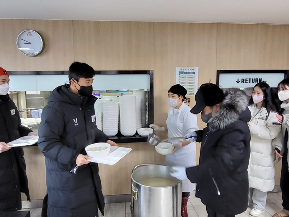 윤홍근 대한빙상경기연맹 회장(오른쪽)이 지난 1일 빙상대표팀 선수단을 격려하기 위해 직접 떡국 배식에 참여했다. [사진=대한빙상경기연맹]